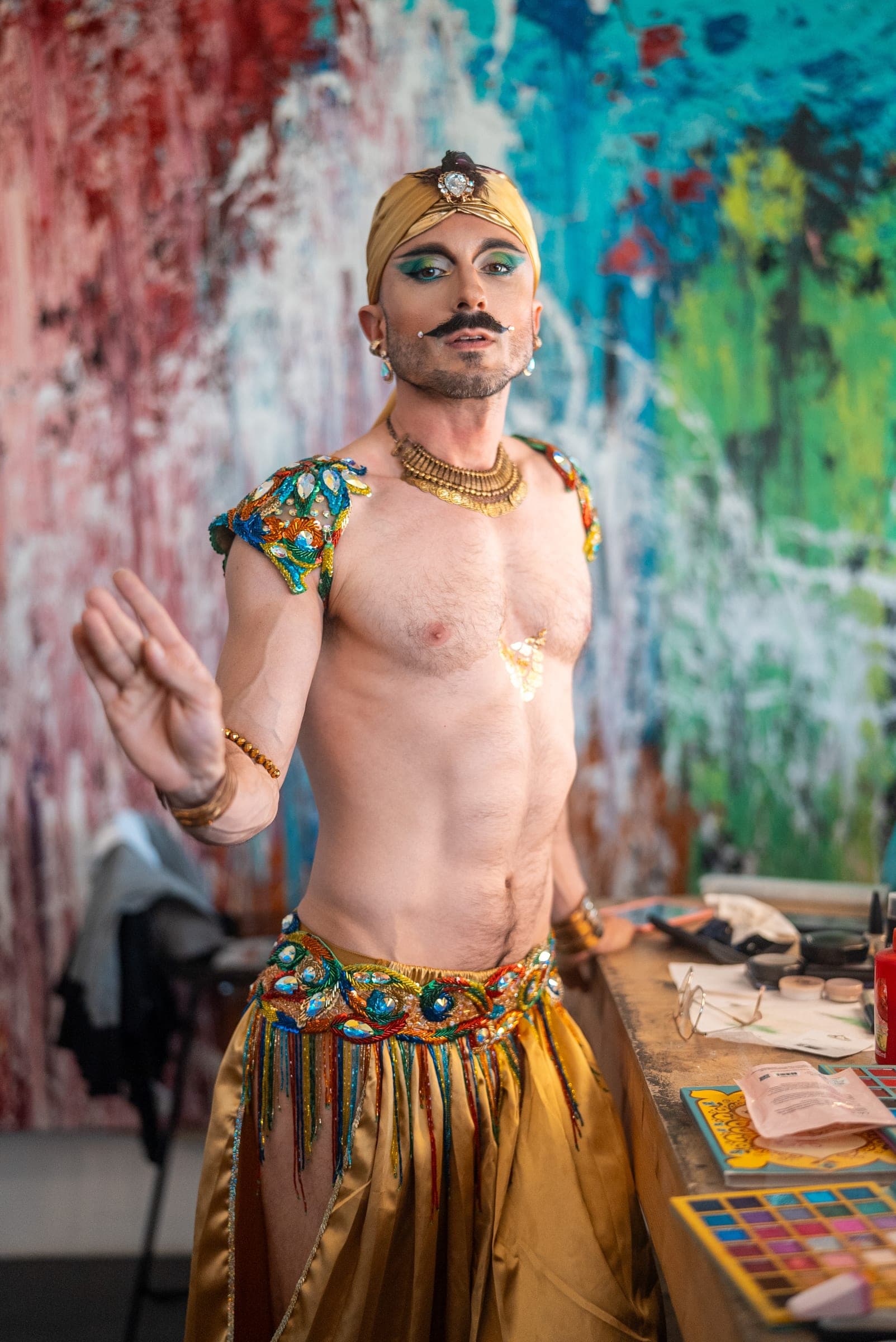 A performer in a gold costume and stage makeup
